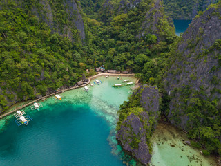 Obraz premium Aerial view to tropical lagoon with azure water and traditional sailing boats near Kayangan Lake, Coron island. Palawan, Philippines.