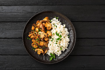 Risotto with  champignons mushrooms on black stone background .