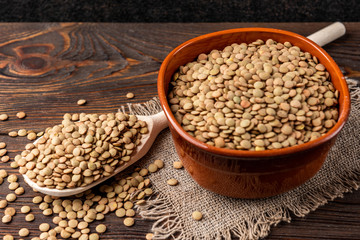 Green lentil on wooden background.