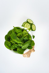 Fresh green leaves spinach, slices of cucumber and ginger isolated on a white background. Copy space for text. Healthy and detox concept