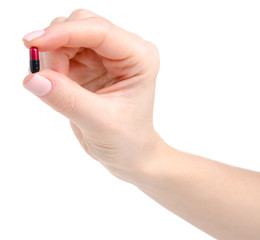 Pill capsule black red in hand medicine health on white background isolation