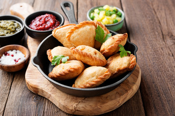 Vegetarian samosas filled with potato and green pea served with different sauces .Indian special traditional street food. 
