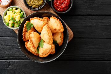 Vegetarian samosas filled with potato and green pea served with different sauces .Indian special traditional street food. 