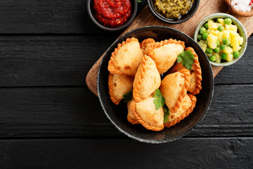 Vegetarian samosas filled with potato and green pea served with different sauces .Indian special traditional street food. 