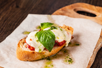 Fototapeta na wymiar Traditional italian bruschetta with cherry tomatoes, cream cheese, basil leaves