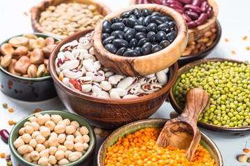 Legumes, lentils, chikpea and beans assortment on white.
