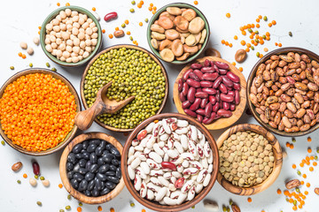 Legumes, lentils, chikpea and beans assortment on white.