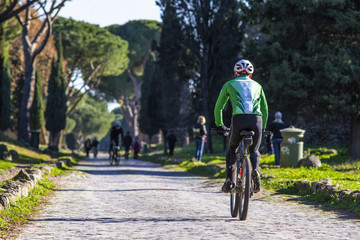 Obraz na płótnie Canvas ciclisti e turisti in bicicletta lungo l'Appia Antica a Roma