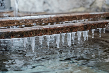 icicles formed above a  traditional water tank, in a village in the French Alps