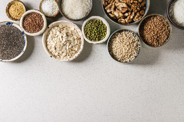 Variety of raw uncooked grains superfood cereal chia, linen, sesame, mung bean, walnuts, tapioca,...