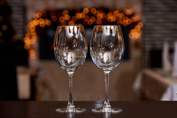 Two empty clean glasses with reflection on a blurred background with bokeh.