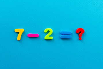 Naklejka premium math action from colored plastic numbers on blue paper background
