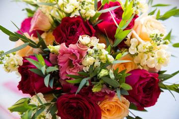 A pair of wedding gold rings on a bouquet of colorful flowers, close up shot