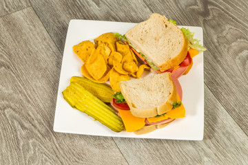 Baloney Sandwich on Sour Dough Bread with pickles and chips on Rustic BG