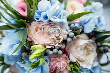 A pair of wedding rings on a bouquet of colorful flowers, close up shot