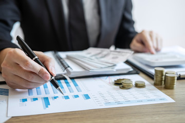 Businessman accountant counting money and making notes at report doing finances and calculate about cost of investment and analyzing financial data, Financing Accounting Banking Concept