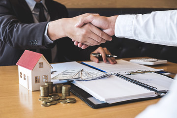 Broker and client shaking hands after signing contract approved form