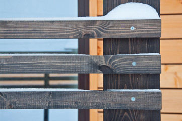 Wooden fence of a private house. Background in snowy weather.
