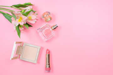Cosmetics and flowers on a pink background. Beauty concept.