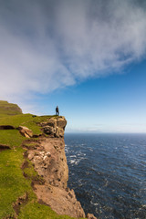 Man standing on cliff in Faroe Islands, Denmark