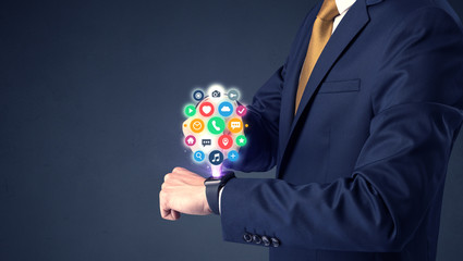 Businessman wearing smartwatch with colored application symbols on it.