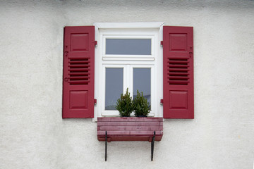 Old ancient wooden window with blinds or shutters. Scenic original and colorful view of antique windows in old city Sindelfingen, Germany. Isolated on wall. No people. Front view. Old fashioned style. - 243027686