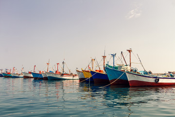 Fototapeta na wymiar Colorful fishing boats anchored at the pier of Paracas, Peru