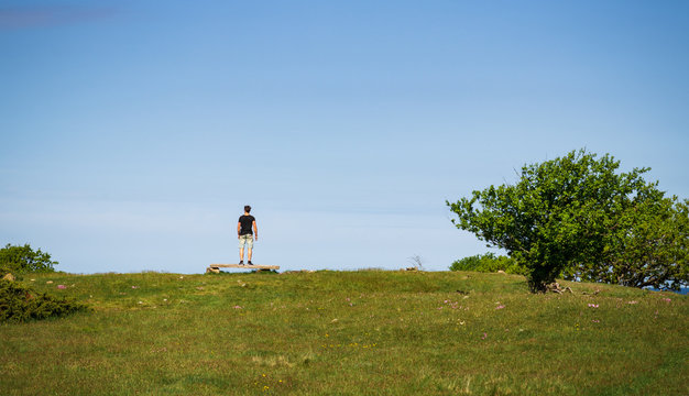 Person standing on a bench looking out over the ocean in the island of Hallands Väderö in southern Sweden. 