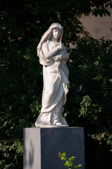 Statue of beautiful woman silver color in the green park
