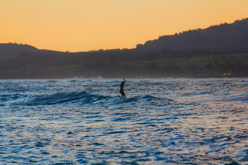 Naklejka premium Surfen bei Dämmerung auf Hawaii, Oahu