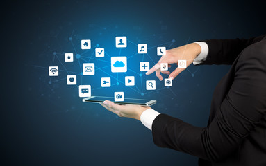 Female hand touching tablet with application icons above