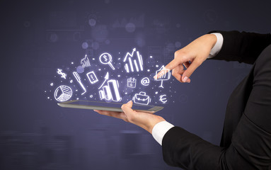 Elegant hand holding tablet with chalk drawn social media symbols above
