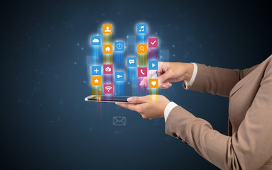 Female elegant hand holding tablet with colourful application icons