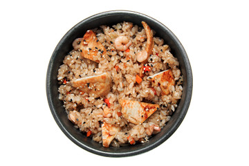 Rice with fried chicken, shrimps, vegetables and sesame in the black bowl. Isolated on white background.