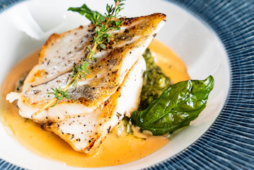 Fried fish fillet. Cod with sauce and herbs