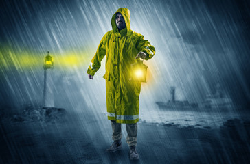 Man at the coast coming in raincoat with glowing lantern concept

