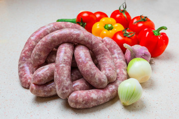 Assorted raw sausage for barbecue with vegetables.