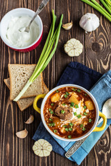 Traditional Ukrainian borsch with meat. Plate of red beetroot soup on rustic background. Traditional Ukraine food cuisine