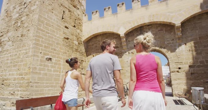 Friends walking on travel vacation together having fun Alcudia Old Town, Mallorca, Spain. Group of friends traveling together in Majorca on Europe vacation.