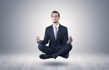 Businessman levitates and sitting in yoga position in an empty infinity space
