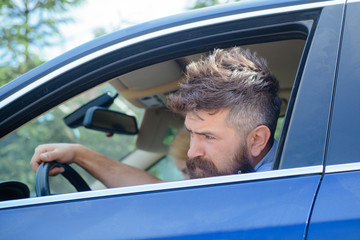 Eco driving is an ecologic driving style. Bearded man travel by automobile transport. Hipster enjoying road trip. Eco friendly and sustainable travel. Travelling by road transport. Using green energy