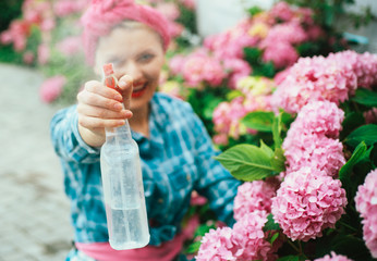 Flower care and watering. soils and fertilizers. hydrangea. Spring and summer. happy woman gardener with flowers. woman care of flowers in garden. Greenhouse flowers. Passionated about her job