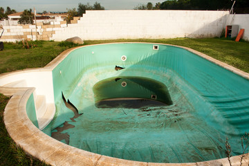 Old abandoned swimming pool with dirty water