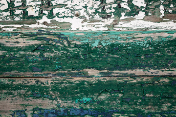 background of a green peeling paint on a wooden surface