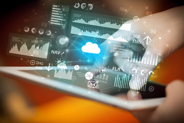 Businessman using tablet with flying application icons around
