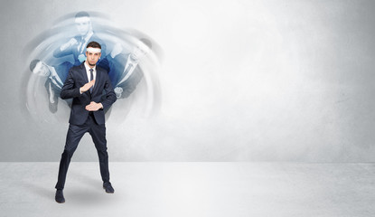 Young businessman in suit fighting with empty wall background
