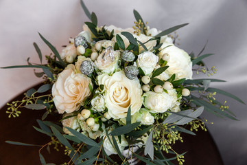 A pair of wedding rings on a bouquet of white flowers, close up shot