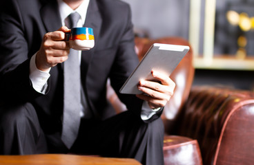 young business man is following developments while having coffee