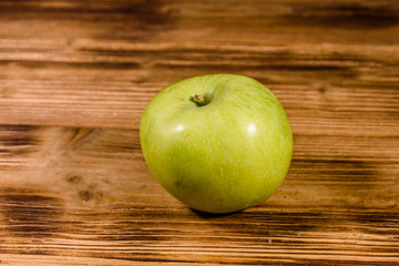 Ripe green apple on a wooden table