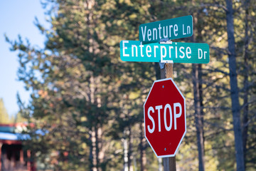 Intersection of Venture lane and Enterprise drive streets with a stop sign below them. Concept for free market and capitalism.